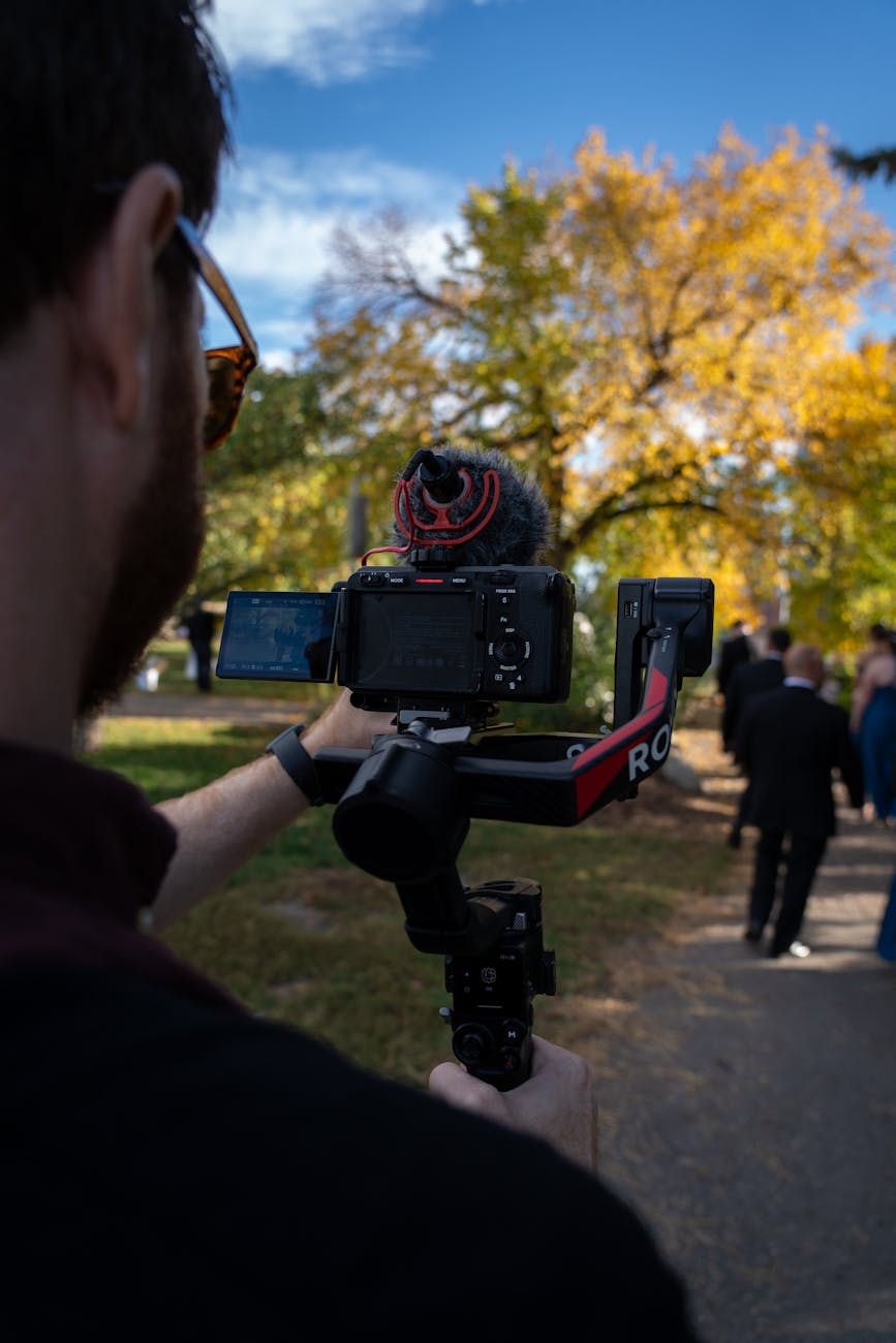 videographer shooting autumn wedding outdoors
